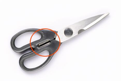 Makaze sa nazubljenim zubićima između drški i sečiva na stolu