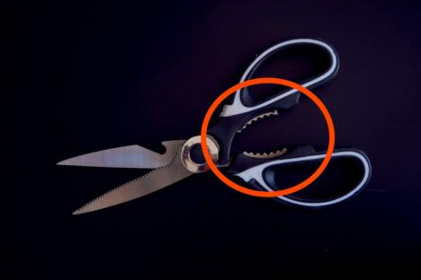 Makaze sa nazubljenim zubićima između drški i sečiva