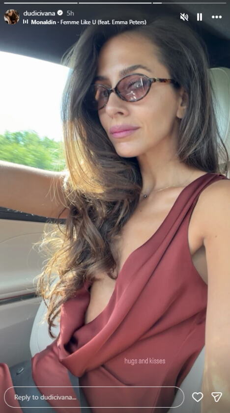 Ivana Dudić vozi auto, nosi majicu sa vrlo dubokim dekolteom