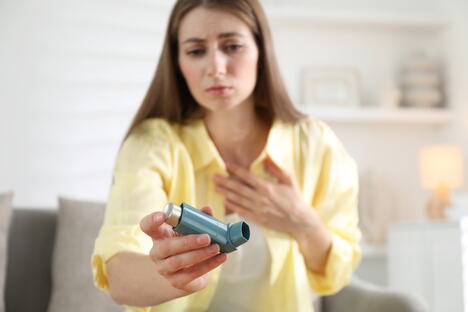 mlada žena sa astmom uzima inhalator da olakša disanje