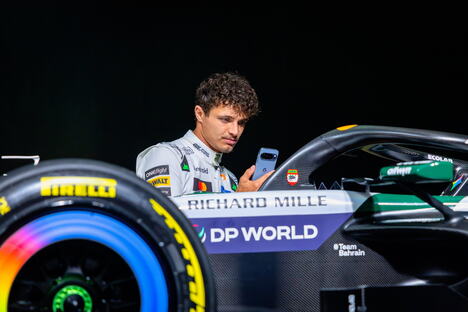 Lando Noris pored bolida Meklarena u belim bojama za trku u Silverstonu