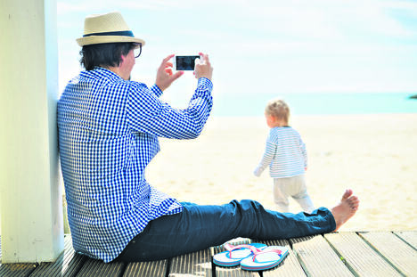 0605stock-photo-rear-side-view-of-father-with-smartphone-taking-picture-of-baby-beach-terrace-on-sunny-day-outside-394008268.jpg