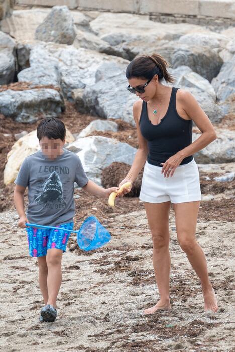 Eva Longorija sa sinom u belom šortsu i crnoj majici šeta plažom u Marbelji