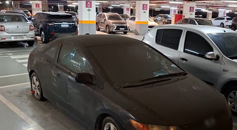 Napuštena crna Honda Civic prekrivena prašinom na aerodromskom parkingu u Rio de Žaneiru (2).PNG