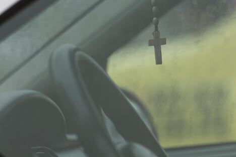 Krst okačen o unutrašnji retrovizor automobila tokom vožnje