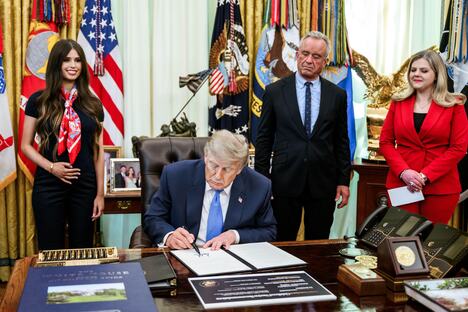 Donald Tramp u Ovalnom kabinetu dok iza njega stoji Džejmi Li Frenklin tokom potpisivanja izvršne naredbe
