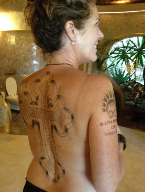 Rita Vilson sa velikim motivom krsta preko leđa na fotografiji kojom promoviše pesmu Stranger With Age.PNG