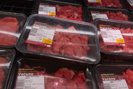 Sveže meso u crnim, žutim, belim i crvenim tacnama u supermarketu, različite boje ambalaže