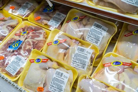 Sveže meso u crnim, žutim, belim i crvenim tacnama u supermarketu, različite boje ambalaže