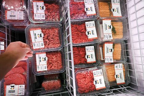 Sveže meso u crnim, žutim, belim i crvenim tacnama u supermarketu, različite boje ambalaže