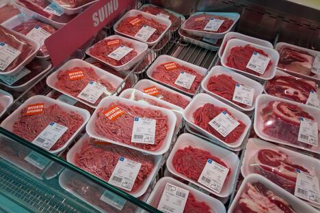 Sveže meso u crnim, žutim, belim i crvenim tacnama u supermarketu, različite boje ambalaže