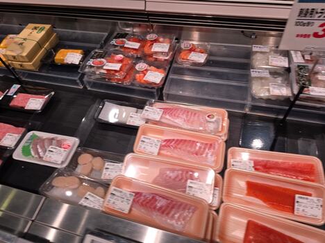 Sveže meso u crnim, žutim, belim i crvenim tacnama u supermarketu, različite boje ambalaže
