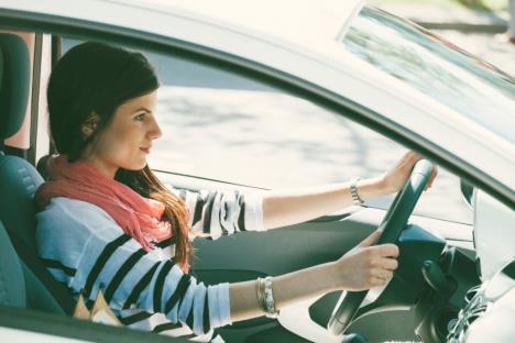 Devojka u prugastoj majici sedi za volanom