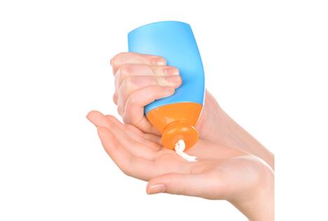 stockphotobottleofsuntancreaminfemalehandsisolatedonwhite264440669.jpg