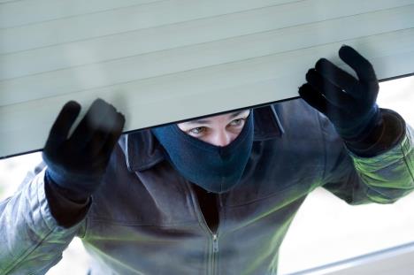 Provalnik je podigao roletnu i gleda kroz prozor