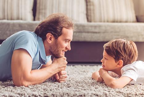 stockphotosideviewofhandsomefatherandhiscutesonlookingateachotherandsmilingwhilespendingtime523948342.jpg