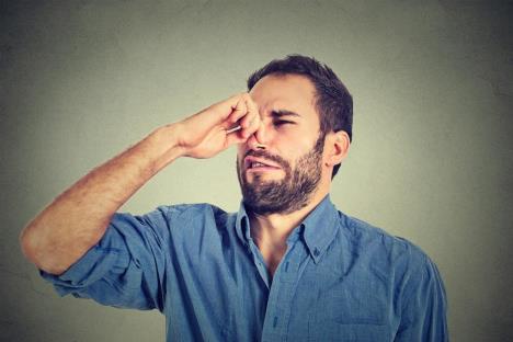 Muškarac zgrožene face drži zapušen nos