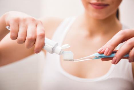 stockphotodentalhealthcarecliniccloseupofyoungwomanisholdingatoothbrushandplacingtoothpaste254735842.jpg