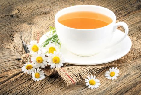 stockphotocupofteaandchamomilesonwoodenbackground328751111.jpg