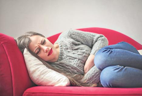 stockphotoyounggirlwithstomachpainlyingonthesofa581614936.jpg