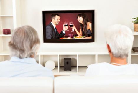 stockphotorearviewofacouplewatchingtelevisionwithasceneonthescreenofayoungmanandwoman112542500.jpg