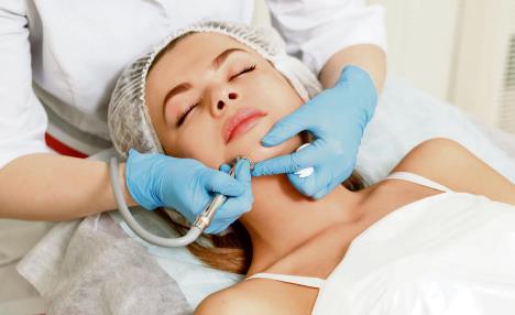 stockphotodermabrasiongirlchinhardwarecosmetologyspafacialrejuvenationmechanicalpeelingskin577810438.jpg