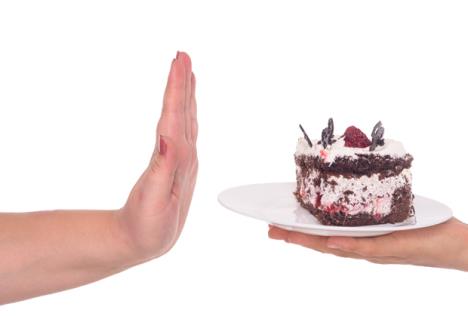 stockphotowomanhandgesturingnotocakefullofcalorieisolatedonwhite222224794.jpg