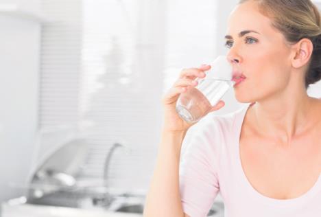 stockphotopensiveblondwomandrinkingwaterinherkitchen148421579.jpg