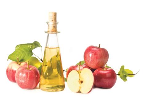 stockphotoapplecidervinegarinaglassvesselandredapplesisolatedonwhitebackground488202202.jpg