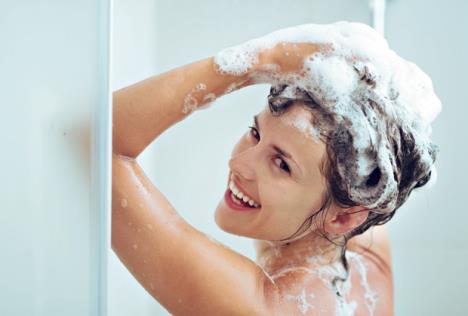 stockphotosmilingyoungwomanwashingheadwithshampoo128732432.jpg