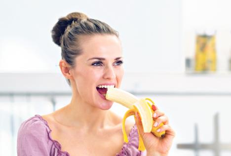 stockphotoyoungwomaneatingbananainkitchen143921122.jpg