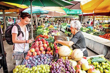 stockphototrogircroatiajulyyoungtouristwomanbuyingfreshfruitfromoldwomanatmarket700823233.jpg