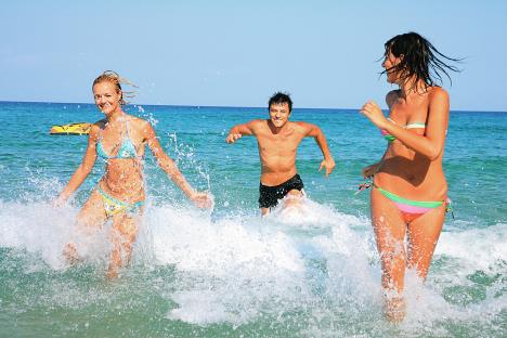 stockphotogroupofthreefriendsmanandwomenonthebeachhavinglotsoffunintheirvacationingreece71722168.jpg