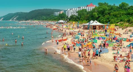 stockphotomiedzyzdrojepolandlotsofpeopleonthesandybeachsunbathingswimminginthe1090392686.jpg