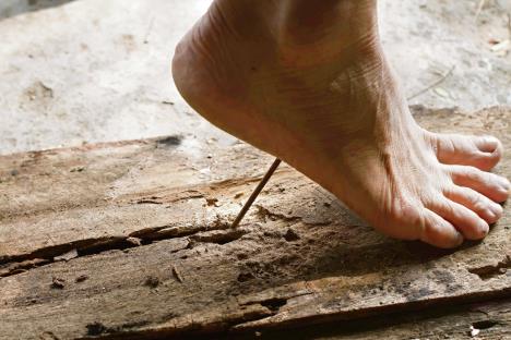 stockphotostepfootonthewoodengroundfootisnearthebigrustynailveryclosedangerousmaybe574539751.jpg