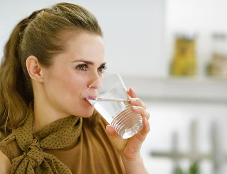 stockphotoyounghousewifedrinkingwaterinkitchen149482910.jpg