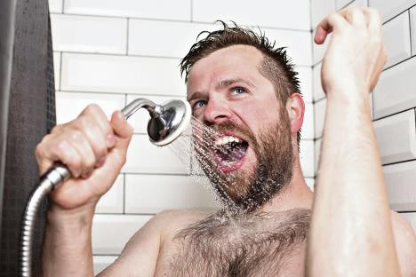 stockphotocutebeardedmansinginginthebathroomusingtheshowerheadwithflowingwaterinsteadofa1149584657.jpg