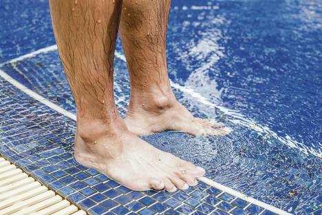 stockphotothemanstandonthepoolbeforgotoswimingcloseuplowsectionofbarefeetbythepool451389325.jpg