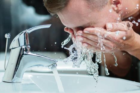 stockphotobrightcaucasianmansprayingwateronhisfaceaftershavinginthebathroomathome155472650.jpg