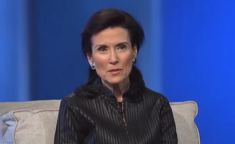 Merilin vos Savant u crnoj košulji sedi na krevetu naslonjena na jastuk