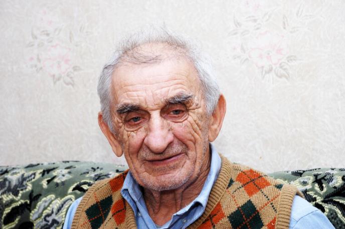 Deda u plavoj košulji i šarenom prsluku - krupan kadar