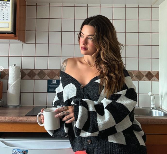 Ešli Reš u kuhinji sa belom šoljom u ruci.jpg