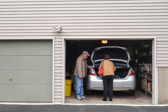 Deka i baka vade stvari iz prtljaga auta u garaži