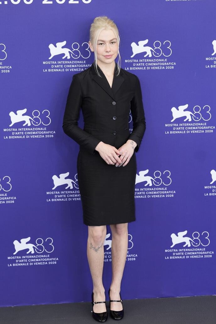 Fibi Bridžers na 83. Venecijanskom filmskom festivalu u crnom kompletu sa vidljivim prirodnim dlačicama na nogama