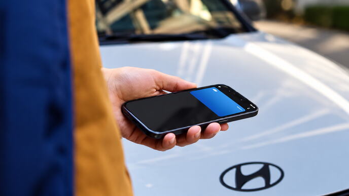 Checking a Phone by the Hyundai Hood.png