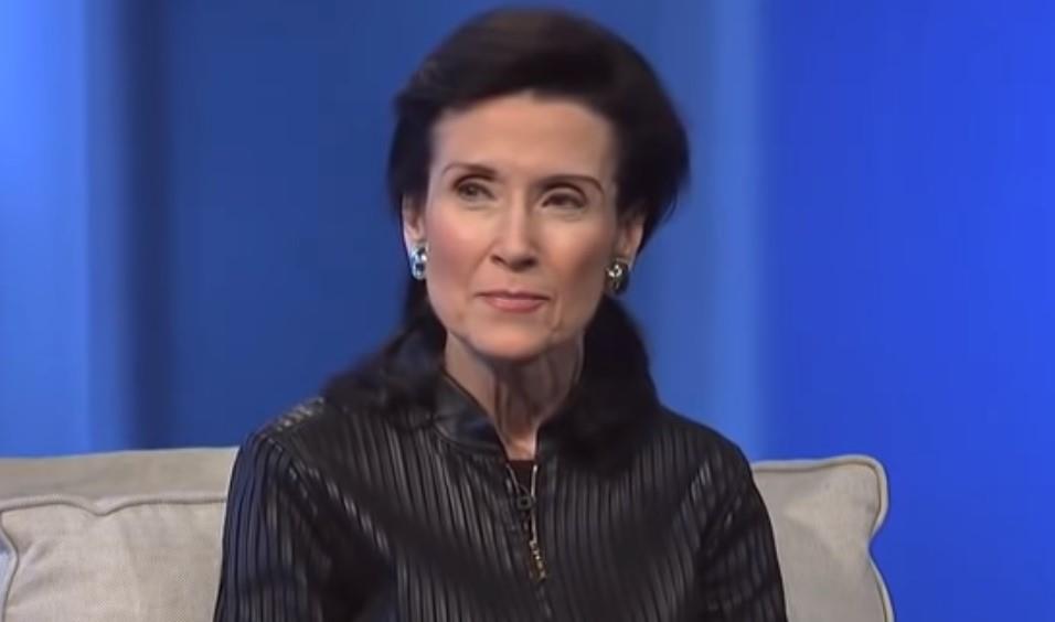 Merilin vos Savant u crnoj košulji sedi na krevetu naslonjena na jastuk